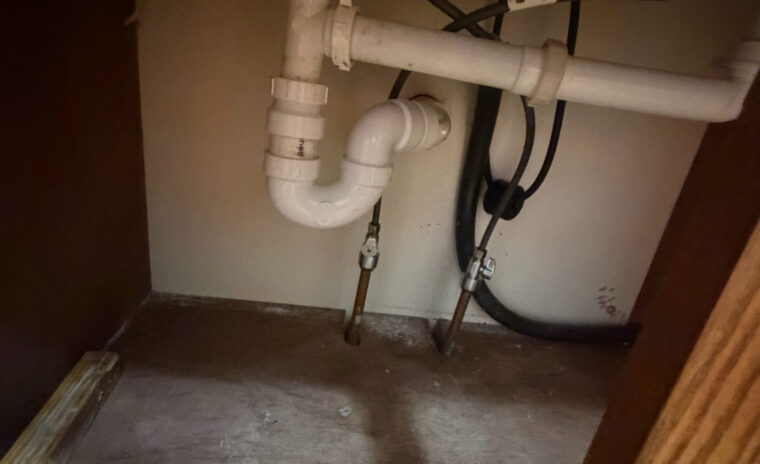 Under-sink plumbing repair inside a kitchen cabinet in Willisburg, KY.