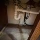 Under-sink plumbing repair inside a kitchen cabinet in Willisburg, KY.
