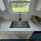 Undermount single-basin stainless steel kitchen sink with high-arc matte black pull-down faucet.