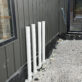 Exterior wall of custom build showing four 3-inch PVC water heater vent pipes extending neatly through wall.
