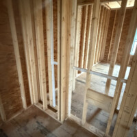 7872BC7F 1ECE 44D3 967F 041A93544CC4 667c9e23 9f10 4438 8eb8 8412e63863b4 Framed bathroom area with toilet flange on subfloor and rough-in plumbing in stud walls.