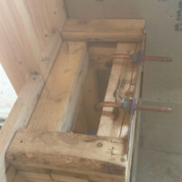 94178A5F B4E8 4CF6 858B 81726D64C339 ef5d723e 0c83 46ff b99d 53df8790e8c9 Top-down view of copper plumbing stub-outs secured with a metal bracket and purple plastic supports inside a wood-framed wall structure for a freestanding tub faucet.