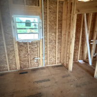 C07BA3C7 C13E 4832 98D0 C566FE917CB3 962d5d9e c4e8 4b10 a833 f6afa4017a2d Bedroom framing showing vertical vent pipe passing through upper top plates.