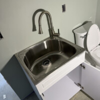 EFC3E939 07FF 4184 B029 F640CE2B09B1 474a495c 6889 48ad 9438 25b23d5823fe 4. Stainless steel shop sink with high-arc brushed nickel faucet and vanity setup.