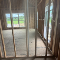 F499044F 9047 4D69 B944 FDC3DA4051AB 1d976d91 37ad 4edf b510 1ae4be12c2c8 A close-up view of intricate PVC drainage and vent piping inside an open wall frame showing drop-ear drops and sanitary elbows routed cleanly for future fixtures