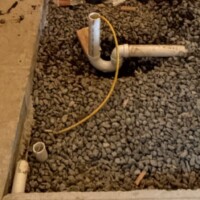 IMG 1814 Under-slab P-trap in gravel bedding fitted with an inflatable test plug hose for drain line pressure testing.