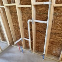 ReactNativeBlobUtilTmp 5gbxmdnuzsyg92iyrj194e PEX supply line routing and vertical PVC vent stack setup inside new home framin