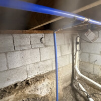 Liberty Pumps SumpJet water powered backup pump installed in Lexington KY 40503 crawl space. Clean blue PEX water line routed to backup sump pump in crawl space.