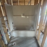 ReactNativeBlobUtilTmp k40z5lvcq7m949rtkrj3a Left-hand fiberglass tub surround installed with rough-in valve and floor waste flange