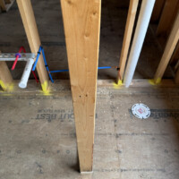 ReactNativeBlobUtilTmp tmv6fecic9nq0ppnoexh3l : Unfinished bathroom framing with toilet flange and vertical PVC DWV stack.