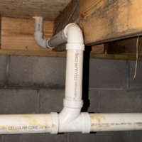 Screenshot 2026 07 25 074358 Detailed view of PVC sanitary tee and vertical waste stack connection under floor joists.
