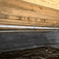 Screenshot 2026 07 25 074456 Precision drain line tight turn fitting under floor joists in a residential crawlspace.
