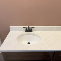 ReactNativeBlobUtilTmp 1fw4sdu4hqijirbef2w6wi Oil-rubbed bronze two-handle bathroom vanity faucet installed on a cultured marble countertop in Springfield, KY.