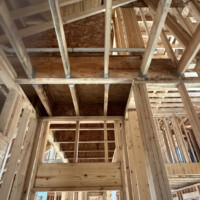 ReactNativeBlobUtilTmp 2x7q7x5xbcgne2x1n5xmcc Horizontal PVC drain pipe with aligned exterior text installed through engineered floor trusses.