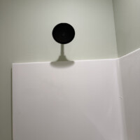 ReactNativeBlobUtilTmp ff6sxge3z4c5oxl14i8fbn Matte black Delta shower head installed on a white fiberglass shower surround.