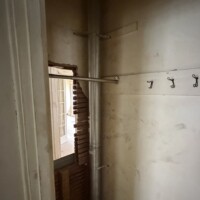 ReactNativeBlobUtilTmp oahcb16cuye77cwlh1hoo Vertical gas flue pipe passing through a first-floor closet wall chase with metal support straps.