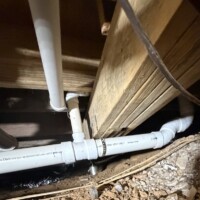 ReactNativeBlobUtilTmp pv5pj9sczdmt3hpny9l0d Low-clearance crawl space routing showing 3-inch Cresline Schedule 40 PVC main drain line fastened under floor joists.