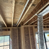ReactNativeBlobUtilTmp tcqj8wy1wxhu53t5bapqg PVC plumbing drain line routed tightly inside a floor joist bay next to a hanging flexible air duct.