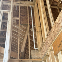 ReactNativeBlobUtilTmp uum2z2710285jk6eztbmp Neat vertical PVC pipe installation through wall framing showing uniform lettering orientation.