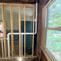 ReactNativeBlobUtilTmp vm9zccc1mt7m18tfyk25t Horizontal PVC vent piping ties routed through wall studs next to a window during rough-in.