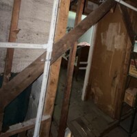 ReactNativeBlobUtilTmp w1rkfddogbx2qtarlazxf PVC vent pipe routed through older diagonal wood framing in an upper story space.