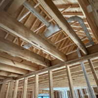 ReactNativeBlobUtilTmp wbul4jic7b7dj8kd9oev Clean PVC DWV pipe rough-in with aligned manufacturer lettering running through wooden roof trusses.
