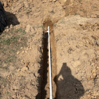 ReactNativeBlobUtilTmp dkeiffmcdp8vtfum8yrvph Deep trench excavation for agricultural water pipe installation in Central Kentucky soil.