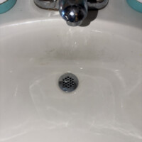 ReactNativeBlobUtilTmp h1ojr6f4ymw9mpou46nq8f Newly installed chrome grid strainer drain body mounted in white porcelain sink basin.