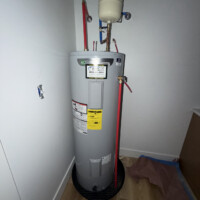 ReactNativeBlobUtilTmp olgngbo3958fm16vl5cybj Under-sink plumbing cabinet setup featuring PVC P-trap assembly and color-coded PEX water supply lines with shutoff valves.