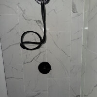 ReactNativeBlobUtilTmp xwsu8ar8cbyp1nouk656g Custom tile shower wall featuring a matte black handheld showerhead, flexible hose, and single-handle control valve.